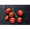 red tomatoes with green salad on dark wooden background
