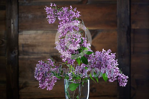 Lilac flowers against brown wooden background Lilac flowers against brown wooden background