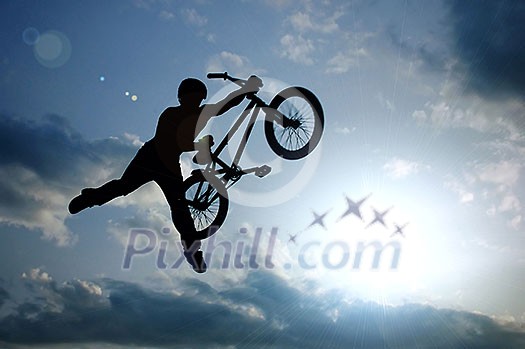 silhouette of boy with bicycle jumping in air silhouette of boy with bicycle jumping in air
