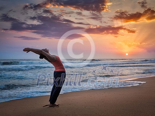 Young sporty fit woman doing yoga Sun salutation Surya Namaskar pose Hasta Uttanasana on tropical beach on sunset Young sporty fit woman doing yoga Sun salutation Surya Namaskar pose Hasta Uttanasana on tropical beach on sunset