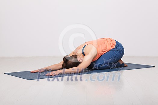 Beautiful sporty fit yogini woman practices yoga asana balasana (child's pose) - resting pose or counter asana for many asanas in studio Beautiful sporty fit yogini woman practices yoga asana balasana (child's pose) - resting pose or counter asana for many asanas in studio