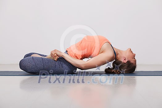 Beautiful sporty fit yogini woman practices yoga asana Matsyasana - fish pose in studio Beautiful sporty fit yogini woman practices yoga asana Matsyasana - fish pose in studio