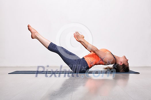 Beautiful sporty fit yogini woman practices yoga asana Uttana padasana - raised legs pose Beautiful sporty fit yogini woman practices yoga asana Uttana padasana - raised legs pose