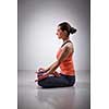 Beautiful fit yogini woman meditating  in yoga asana Padmasana (Lotus pose) cross legged position for meditation with Chin Mudra - psychic gesture of consciousness