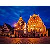 Vintage retro effect filtered hipster style image of Riga Town Hall Square, House of the Blackheads and St. Roland Statue illuminated in the evening twilight, Riga, Latvia