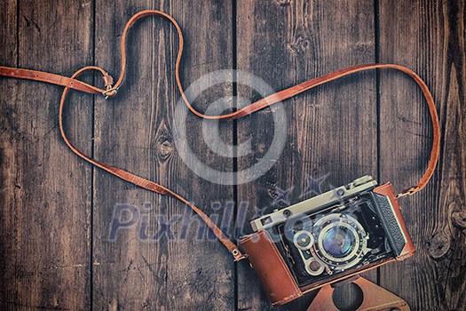 Photography concept background - old retro vintage camera on grunge wooden texture Photography concept background - old retro vintage camera on grunge wooden texture