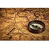 Travel geography navigation concept background - old vintage retro compass on ancient world map