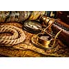 Travel geography navigation concept background - old vintage retro compass with sundial, spyglass and rope on ancient world map