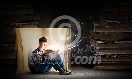 Teenager boy wearing jeans and shirt and reading book Teenager boy wearing jeans and shirt and reading book