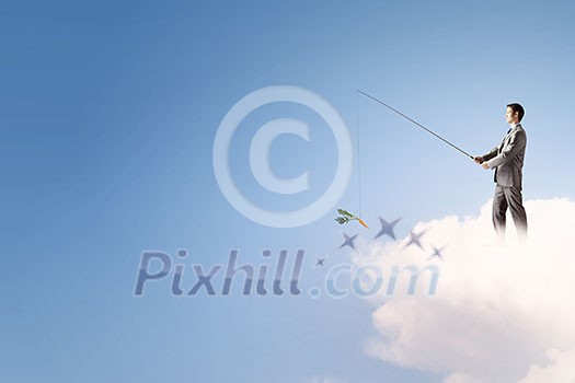 Young businessman standing on cloud high in sky and fishing