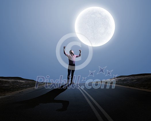 Young screaming man at night with big full moon at background Young screaming man at night with big full moon at background