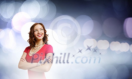 Young woman in red dress against bokeh background Young woman in red dress against bokeh background