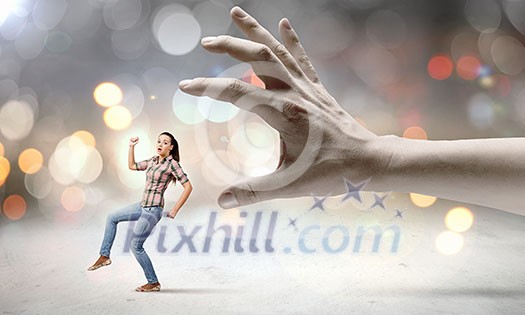 Young woman in casual escaping from big male hand Young woman in casual escaping from big male hand
