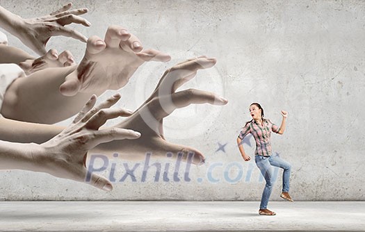 Young woman in casual escaping from big male hand Young woman in casual escaping from big male hand