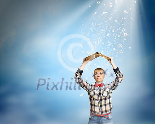 Young woman in shirt holding book above head Young woman in shirt holding book above head
