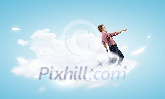 Young man in casual walking on cloud high in sky Young man in casual walking on cloud high in sky