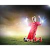 Football player standing on knees and screaming with joy