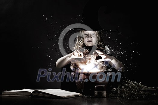 Little Halloween witch reading conjure above pot Little Halloween witch reading conjure above pot