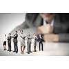 Businesswoman looking at group of businesspeople in miniature