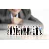Businesswoman looking at group of businesspeople in miniature