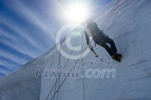Low angle view of man climbing glacier Low angle view of man climbing glacier