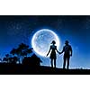 Silhouettes of couple against big moon at background