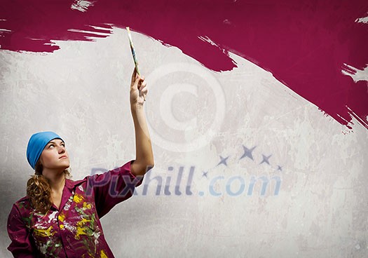 Young woman painting wall in colors with brush Young woman painting wall in colors with brush