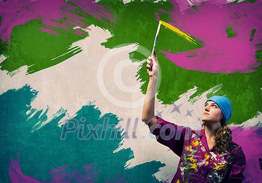 Young woman painting wall in colors with brush Young woman painting wall in colors with brush