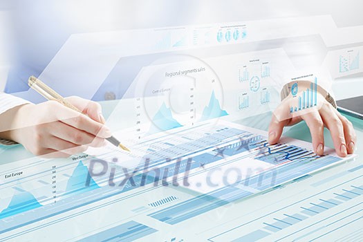 Businessman hand writing with pen and digital business infographs Businessman hand writing with pen and digital business infographs