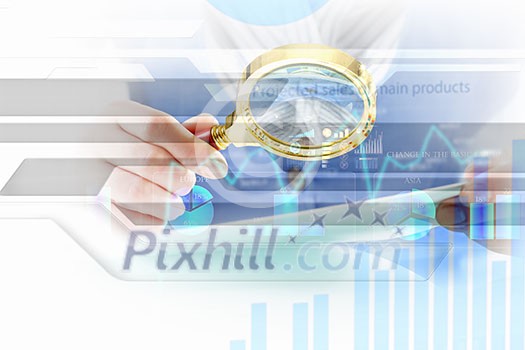 Close up of business person investigating infographs with magnifier Close up of business person investigating infographs with magnifier
