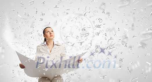 Portrait of young businesswoman in white suit reading blank newspaper Portrait of young businesswoman in white suit reading blank newspaper