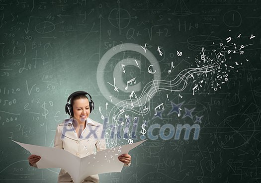 Portrait of young businesswoman wearing headphones and reading blank newspaper