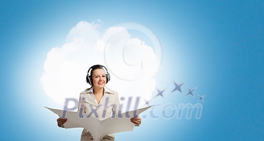 Portrait of young businesswoman wearing headphones and reading blank newspaper Portrait of young businesswoman wearing headphones and reading blank newspaper
