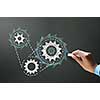 Businessman hand drawing with chalk gears mechanism as teamwork concept