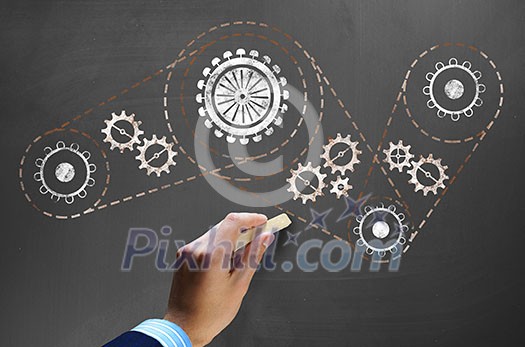 Businessman hand drawing with chalk gears mechanism as teamwork concept Businessman hand drawing with chalk gears mechanism as teamwork concept