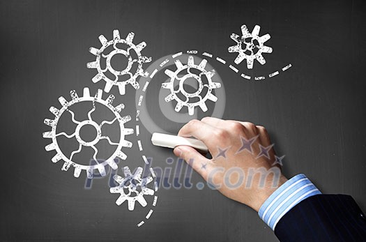 Businessman hand drawing with chalk gears mechanism as teamwork concept