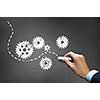 Businessman hand drawing with chalk gears mechanism as teamwork concept