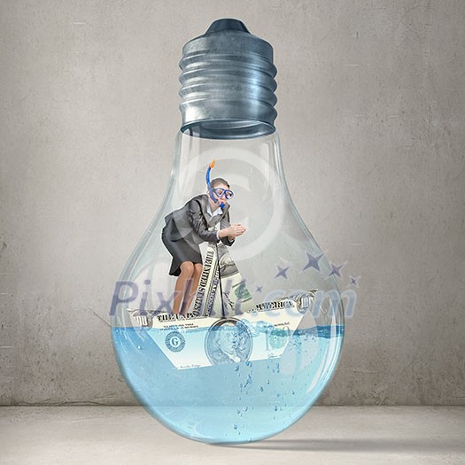 Young businesswoman in suit and diving mask jumping in lightbulb with water Young businesswoman in suit and diving mask jumping in lightbulb with water