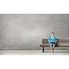 Plus size woman with book in hands sitting on bench