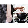 Young woman cooking in her modern kitchen (shallow DOF; color toned image)