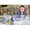Young woman looking for the right pills in a modern pharmacy (shallow DOF; color toned image)