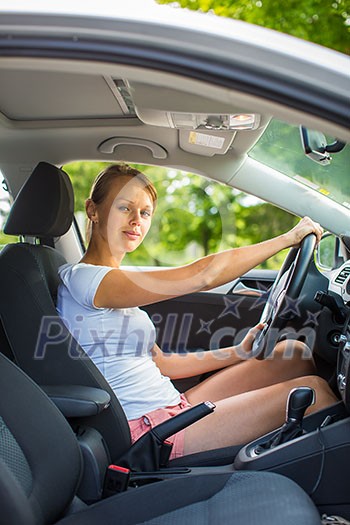 Young woman driving her car, on her way home from work - doing the daily commute Young woman driving her car, on her way home from work - doing the daily commute