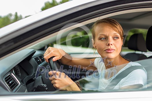 Young woman driving her car, on her way home from work - doing the daily commute Young woman driving her car, on her way home from work - doing the daily commute