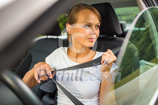 Young woman driving her car, on her way home from work - doing the daily commute Young woman driving her car, on her way home from work - doing the daily commute