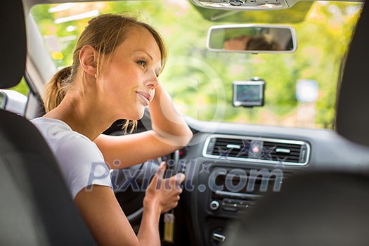 Young woman driving her car, on her way home from work - doing the daily commute Young woman driving her car, on her way home from work - doing the daily commute
