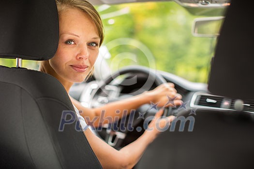 Young woman driving her car, on her way home from work - doing the daily commute Young woman driving her car, on her way home from work - doing the daily commute