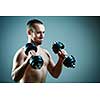 Close up of young man lifting weights over grey background