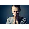 Young woman suffering from severe depression/anxiety/sadness, crying, tears coming from her eyes, blowing her nose
