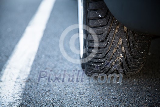 Detail of the tyre of a modern car on road Detail of the tyre of a modern car on road