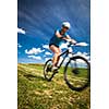 Pretty, young female biker outdoors on her mountain bike (motion blurred image)